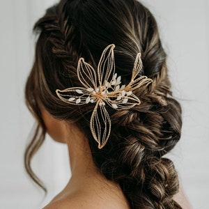 Gold floral hair comb with leaf shapes and small white flower accents