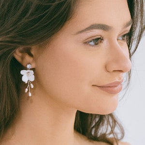 White floral dangle earrings with small pearl-like centers