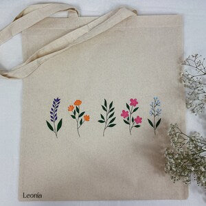Hand-painted jute tote bag with colorful flower stems