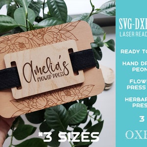 Wooden flower press kit with black fabric straps and botanical label card