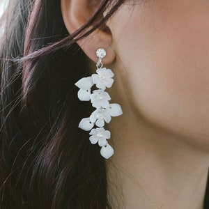 White floral drop dangle earrings with layered flower charms