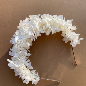 White floral headband with small hydrangea-style blooms on a thin band