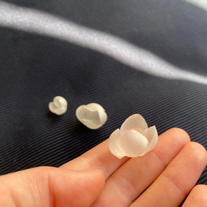 Set of small off-white 3D fabric flower petal appliques in hand