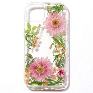 Clear pressed-flower phone case with pink daisies, small white blooms, and green leaves