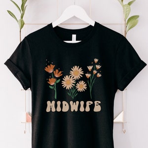 Black midwife shirt with floral bouquet graphic and “MIDWIFE” text on the front