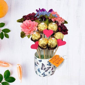 Ferrero Rocher bouquet in floral bucket with pink and burgundy flowers and chocolate truffles