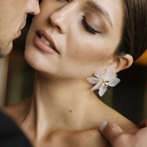 White flower drop earrings with gold-tone stems, bridal lily-style design