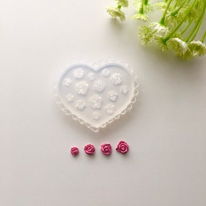 Heart-shaped polymer clay mold with rose flower details, plus small pink rose pieces