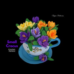 Crochet crocus flower arrangement in blue teacup with purple, orange, and green blooms