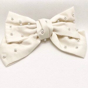 Beige pearl knot bow hair clip with faux pearl details and center knot