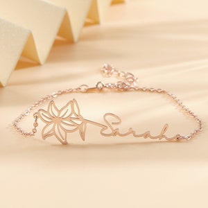 Minimalist birth-flower name bracelet with floral and cursive engraving on a thin chain