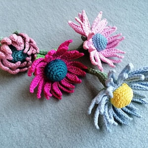 Crochet flower pattern PDF featuring layered pink, blue, and yellow crocheted flowers