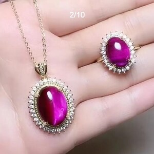 Purple oval tiger eye pendant necklace set with flower setting and metal halo on chains