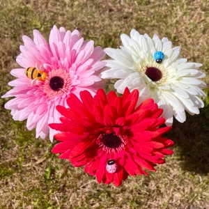 Faux gerbera flower set with pink, red, and white blooms and ladybug and bee accents