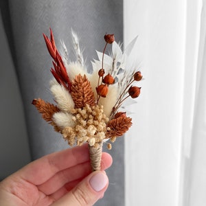 Dried floral boutonniere with terracotta and rust stems, tied with twine