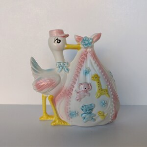 Vintage-style stork baby delivery planter with pastel animal motifs, blue base