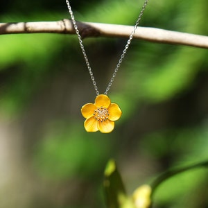 Delicate flower pendant necklace with yellow enamel bloom and small crystal center