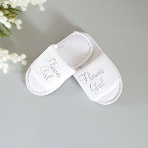 White kids spa slippers with slip-on design and embroidered front lettering