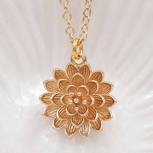 Gold floral pendant necklace with chrysanthemum-style flower and rhinestone center