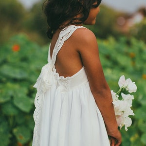 White boho flower girl dress with lace-trimmed open back and sleeveless bodice
