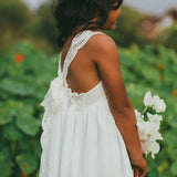 White boho flower girl dress with lace-trimmed open back and sleeveless bodice