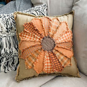 Orange plaid rag-style flower pillow cover with stitched petal shapes and dark center