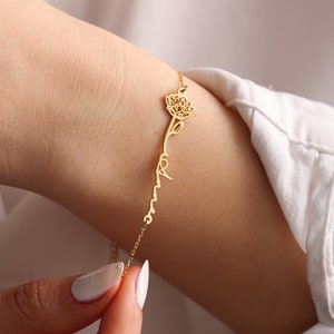 Gold-tone delicate bracelet with flower-shaped charm