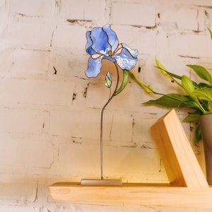 Stained glass iris flower suncatcher on metal stand with green leaves