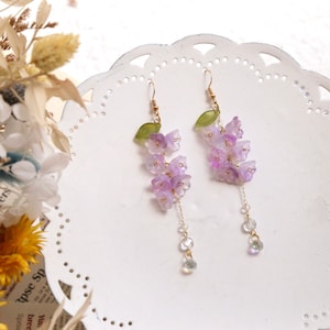 Purple wisteria flower dangle earrings with small beads and green leaf accents