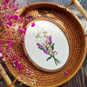 Round wicker embroidery hoop with printed floral design on white fabric