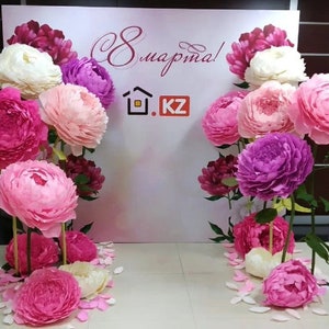 Standing paper peony flowers with stems in pink, purple, and white for a photo backdrop