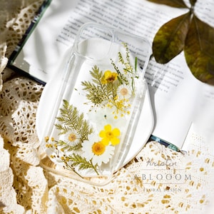 Clear pressed-flower phone case with yellow wildflower design and cutout openings