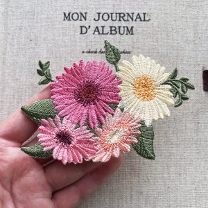 Embroidered flower iron-on patch with pink and cream blossoms and green leaves