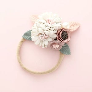 Cream flower headband with pink center, sage leaves, and soft beige elastic band