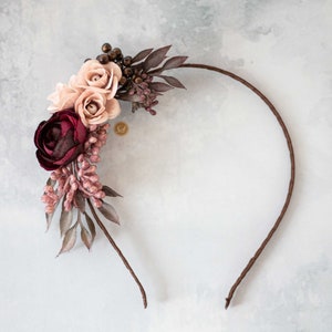 Floral headband with dark burgundy and pink fabric flowers and leafy accents