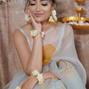 Off-white floral bridal jewelry with headpiece, earrings, necklace, and bracelet