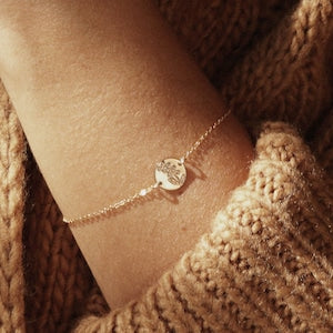 Gold-tone dainty bracelet with small round flower charm on thin chain