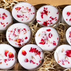 White tea light candles with red rose petals, in round metal cups