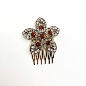 Rhinestone flower hair comb with red center, clear gems, gold-tone metal and comb teeth