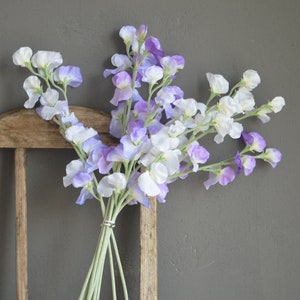 Artificial sweet pea flower stem with purple and white blossoms, green stems, tied bunch