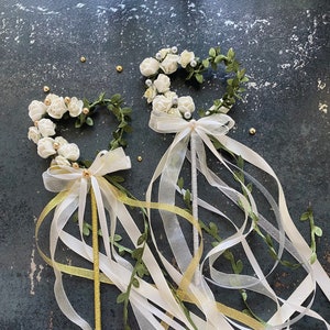 Ivory flower wand with butterfly accents and long white, gold, and green ribbon streamers
