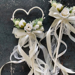 Flower girl wand with heart-shaped frame, ivory roses, and long ivory ribbon streamers