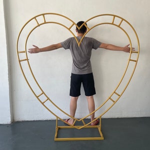 Gold heart-shaped metal arch flower stand with base