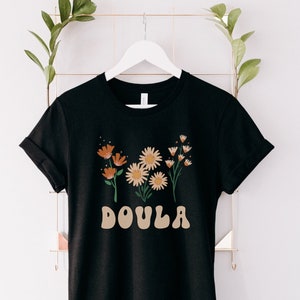 Black short-sleeve doula shirt with orange and white daisy floral front print