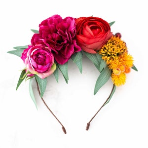 Colorful flower headband with large pink, red, and yellow blooms and green leaves