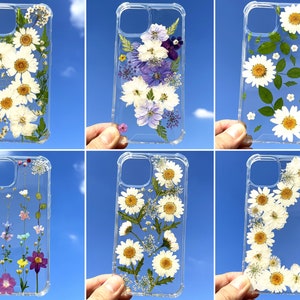 Pressed-flower phone case with clear background and daisies with purple blooms