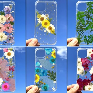 Clear pressed flower phone case with daisies and blue dried flowers, slim protective cover