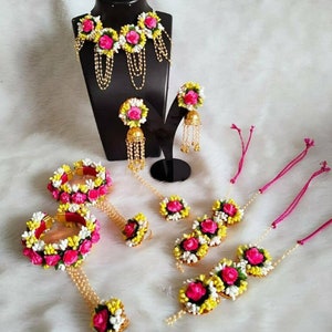 Gold-tone floral jewelry set with pink and yellow stones; necklace, earrings, bangles.