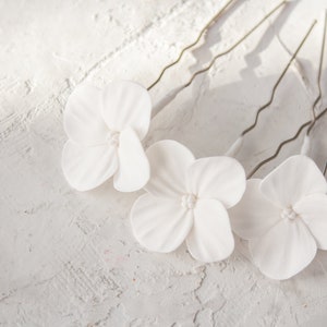 White hydrangea flower hair pins with small white blooms for wedding hairstyles
