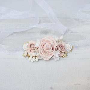 Pastel floral sash with roses, small blossoms, and pearl-like accents